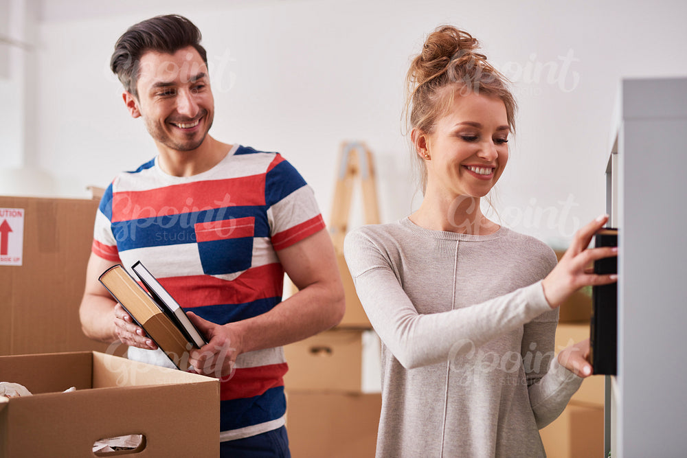 Young couple unpacking moving boxes in new flat