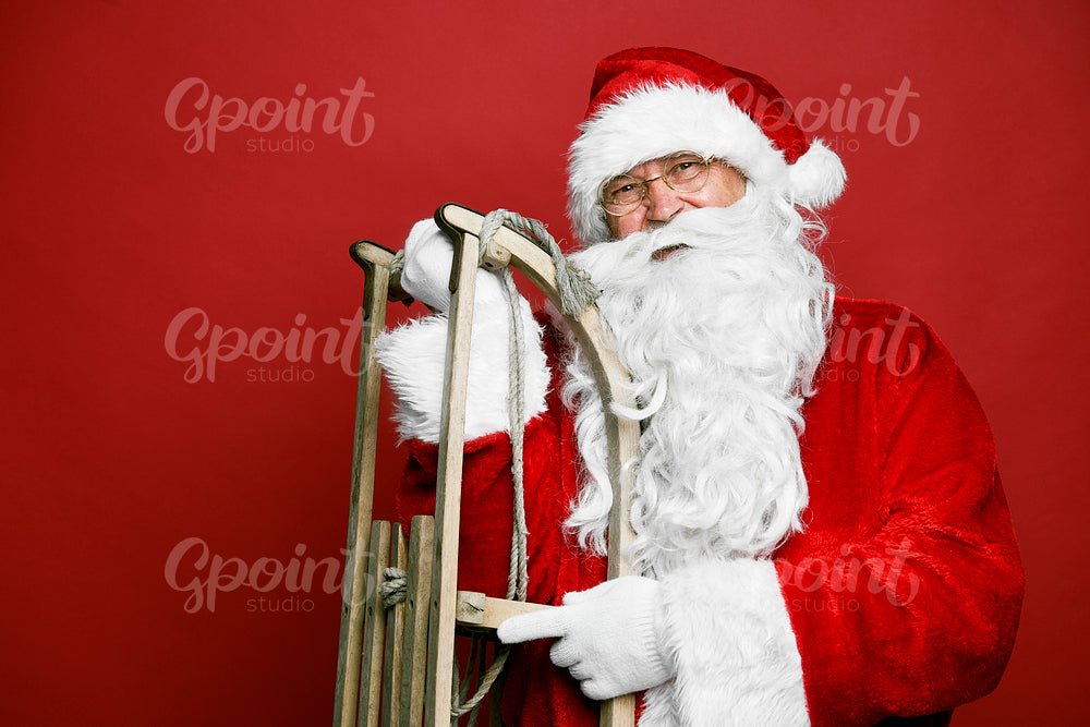 Caucasian Santa Claus with sled on red background 