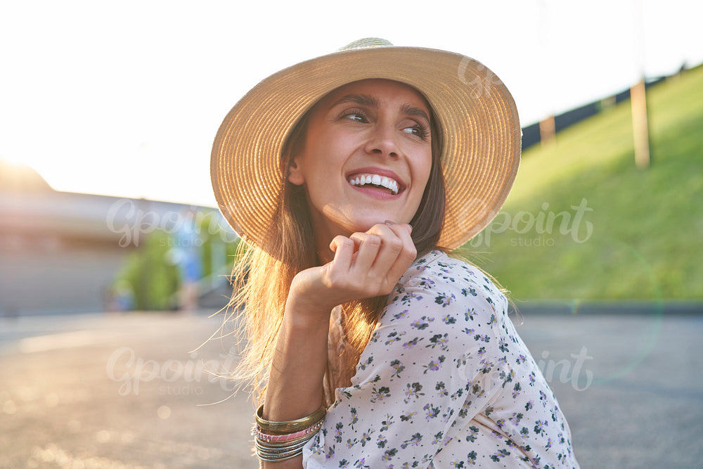 Happy young beautiful woman in a hat during the sunset
