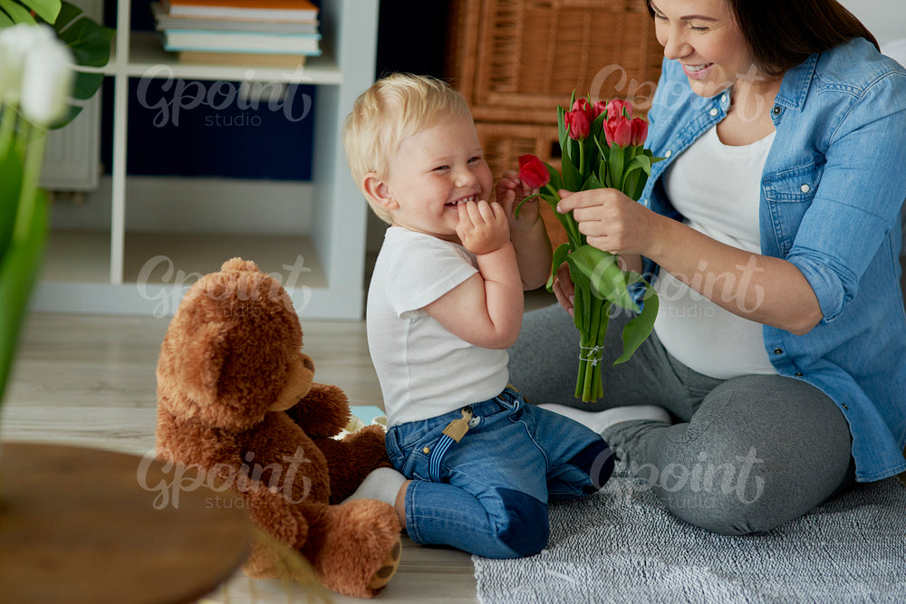 Mother receiving beautiful flowers from her toddler boy