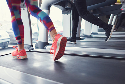Woman and man running on treadmill at gym