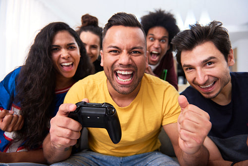 Front view of  emotional man with a joystick and friends