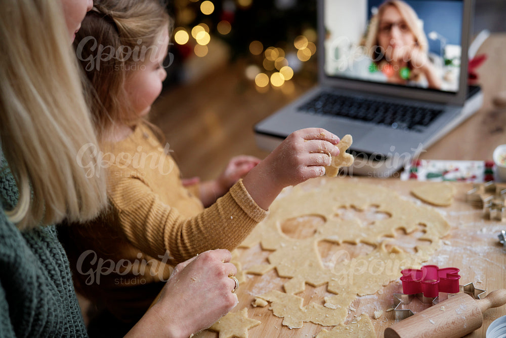 Little girl showing her grandma Christmas cookies during video conference