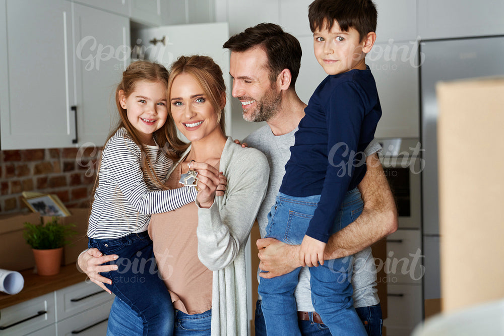 Portrait of smiling family with children in a new apartment