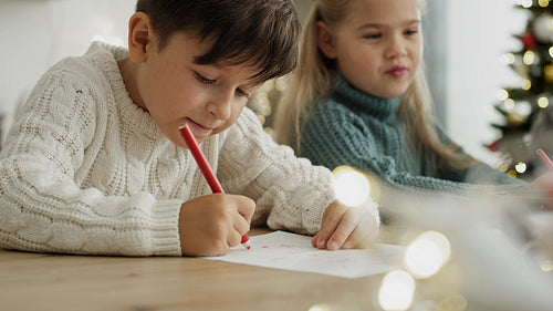 Close up video of little boy writing a letter to Santa Claus