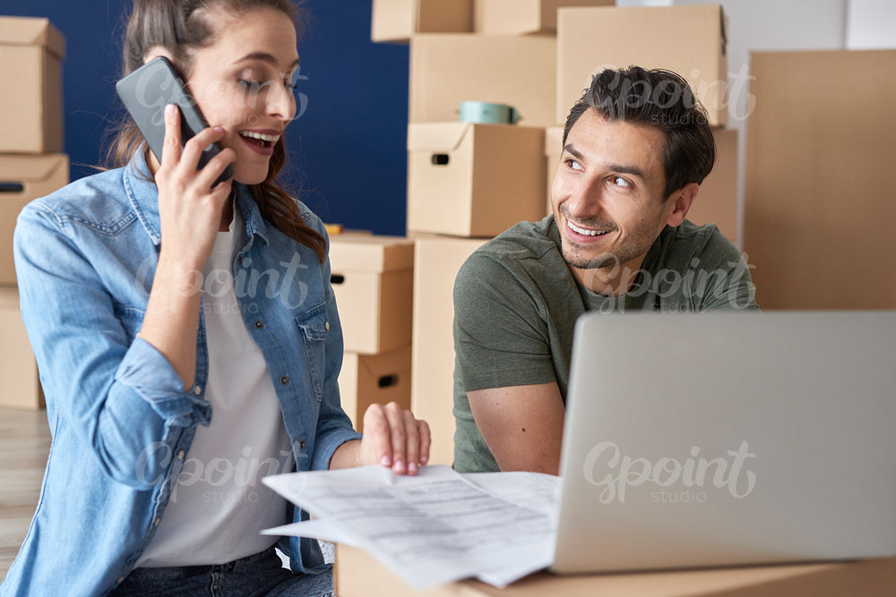 Cheerful couple getting things done via phone