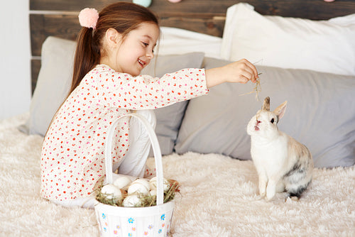 Side view of cute girl feeding the rabbit