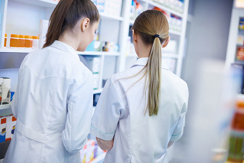 Back view of pharmacists wearing lab coats