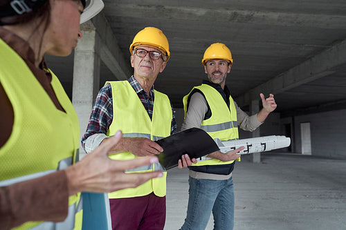 Three caucasian engineers discussing on the construction site