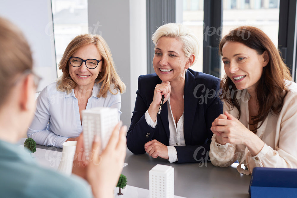 Three mature businesswomen having a conversation at conference table
