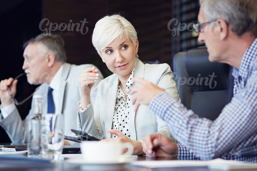 Group of business people huddled around table working