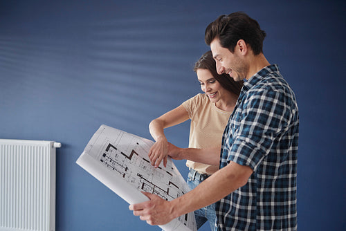 Side view of couple browsing  a home blueprint