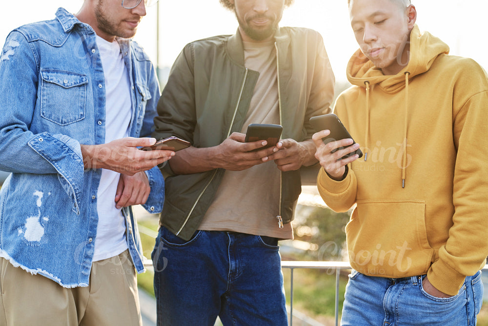 Close up of three young man with mobile phones