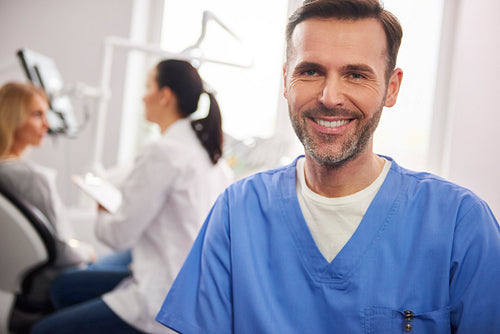 Front view of smiling male dentist in dentist's clinic