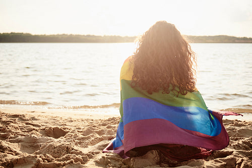 Rear view of young woman covered with rainbow flag