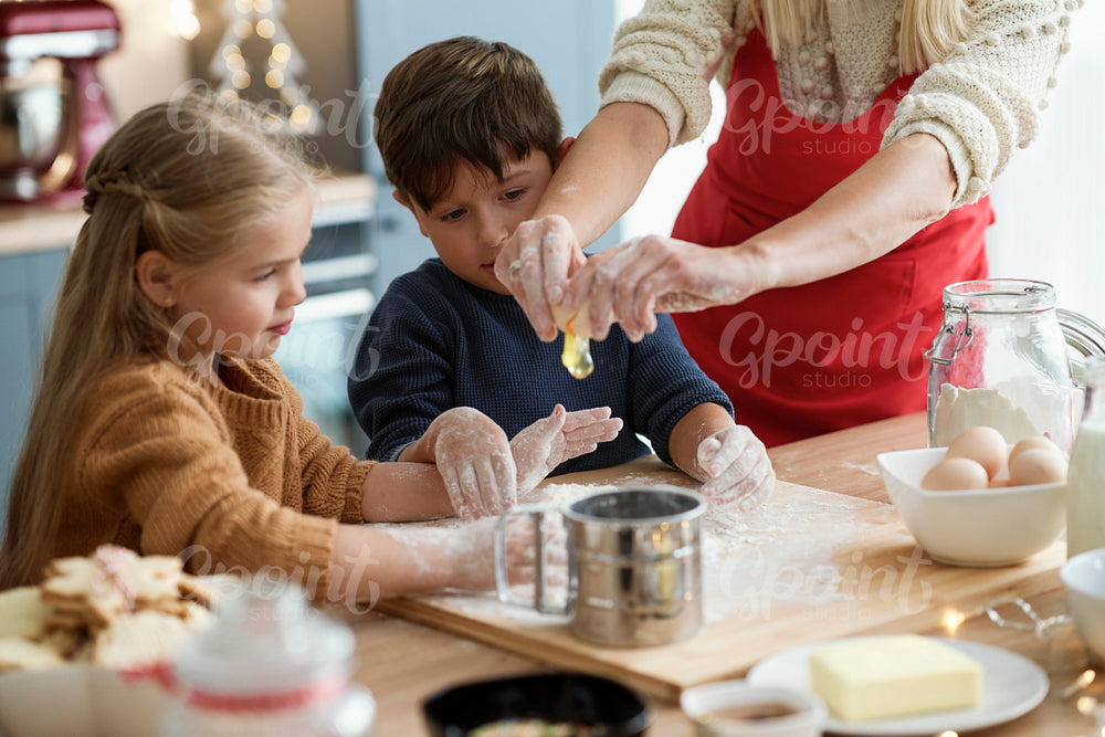 Children looking at egg cracked by mom