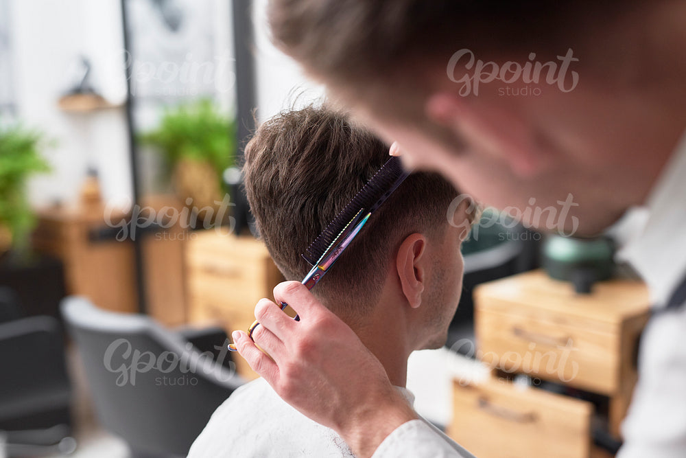 Young man has cutting hair at the hairdresser