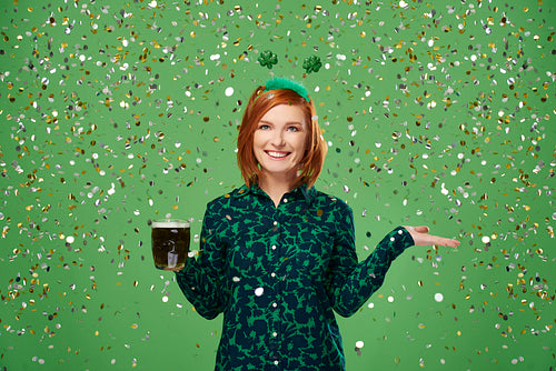 Portrait of woman with beer under a shower of confetti