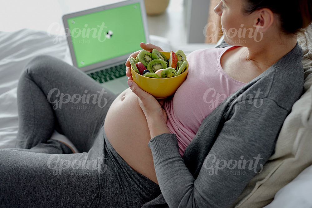 Pregnant woman relaxing in front of computer