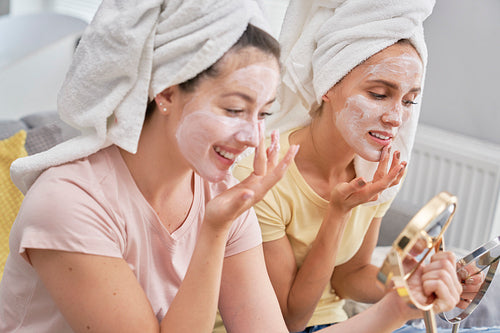 Two girls applying facial mask