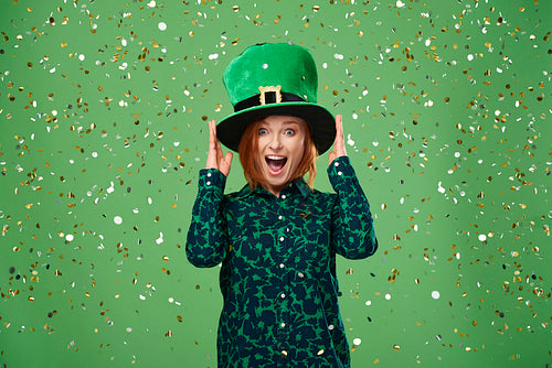 Screaming woman with leprechaun's hat under a shower of confetti