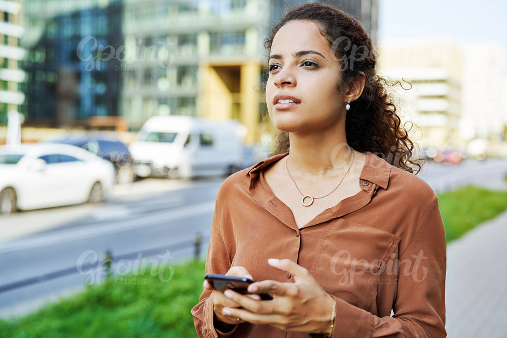 Woman with a phone in her hands in a city