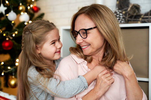 Grandmother and granddaughter looking into each other's eyes during Christmas