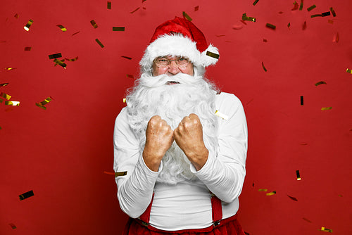 Caucasian Santa Claus cheering with confetti