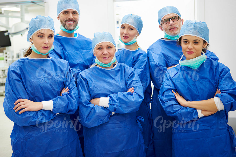 Team of cheerful doctors in surgical uniform