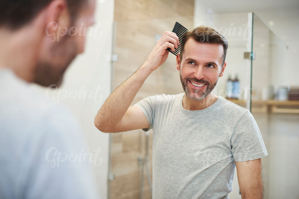 Man combing his hair in the bathroom