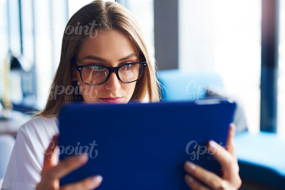 Shot of focused woman using digital tablet