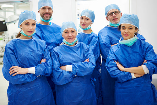 Team of cheerful doctors in surgical uniform
