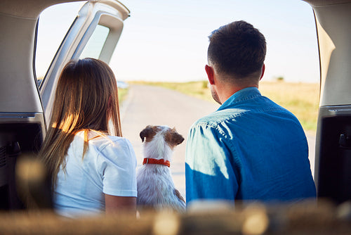 Rear view of young couple and dog enjoying the view