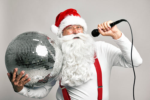 Caucasian Santa Claus singing and holding disco ball