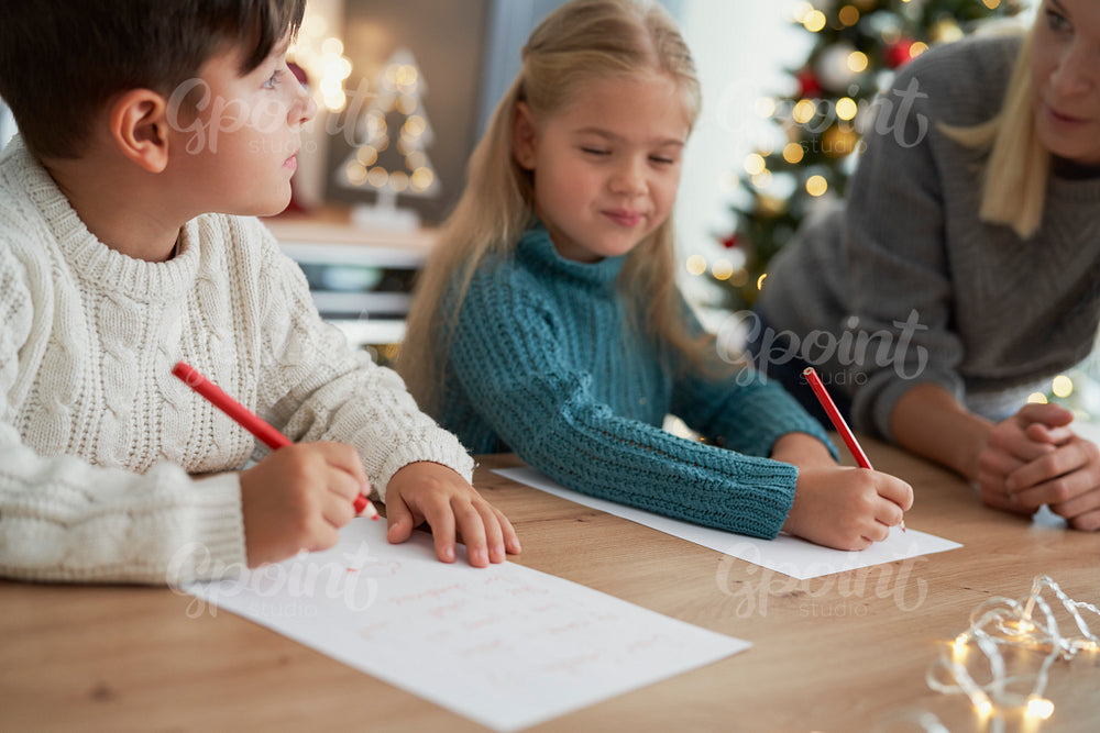 Brother and sister writing a letter to Santa Claus