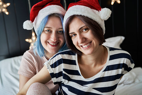 Portrait of happy lesbian couple in Christmas caps