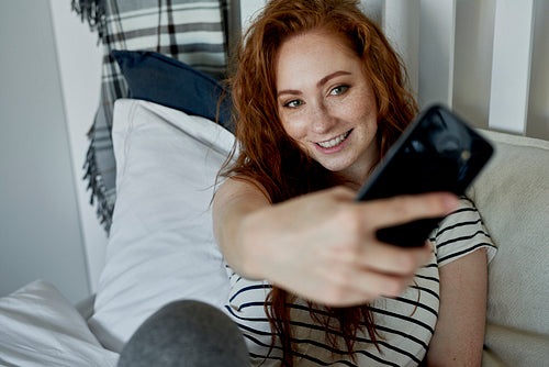 Woman taking selfie in the bedroom