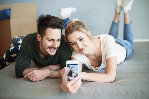 Couple taking picture in their own new bedroom