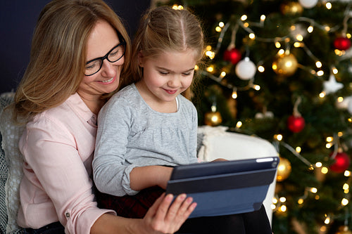 Grandmother with granddaughter using tablet in Christmas time