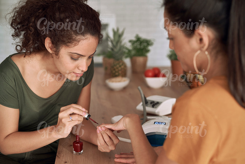Women applying nail polish at home