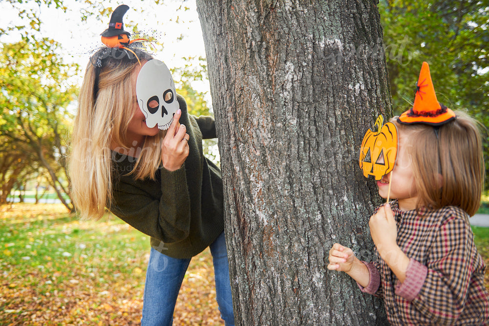 Mother and daughter having fun with Halloween masks