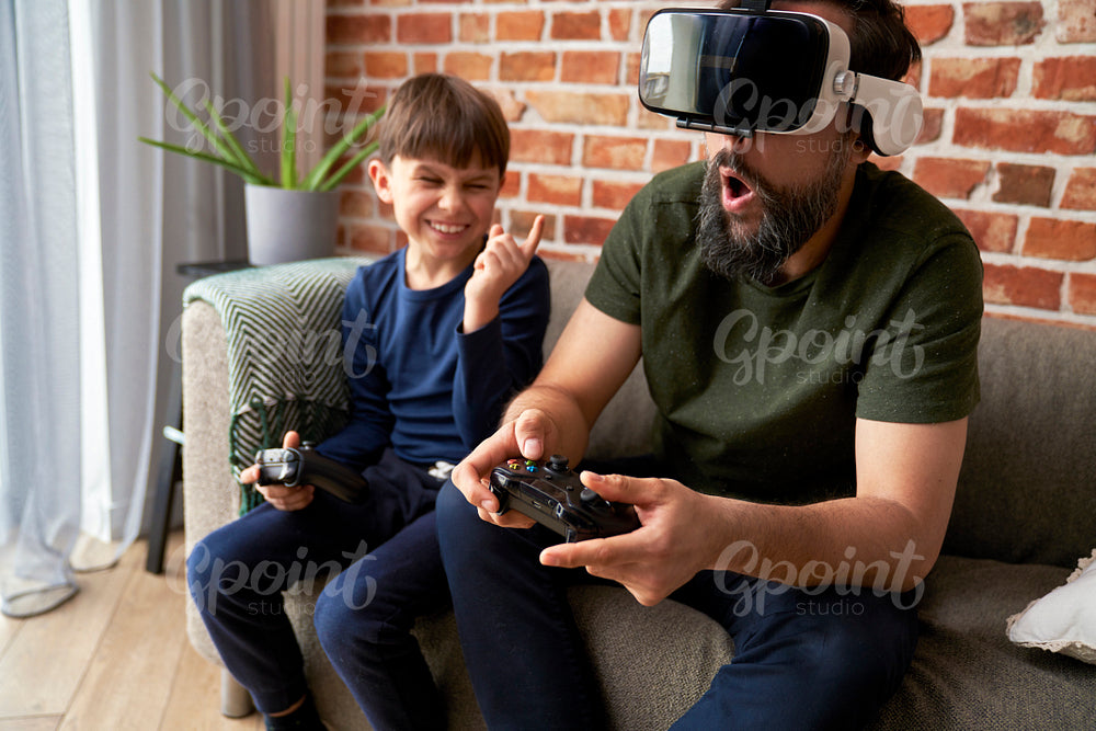 Son laughing at his father while playing video games