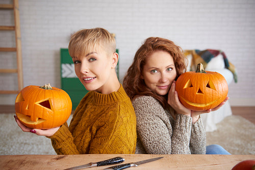 Portrait of happy girls holding pumpkins