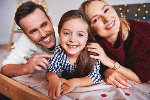 Portrait of family lying in bed at christmas time
