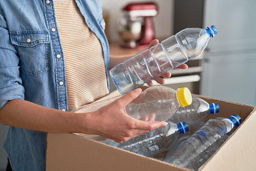 Woman preparing plastic bottles for recycling