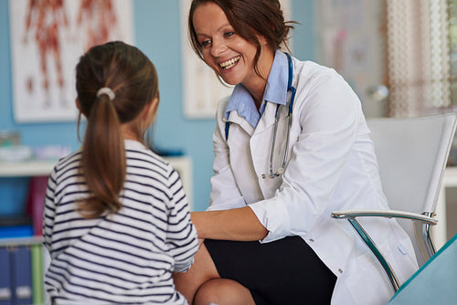 Woman doctor talking to her little patient