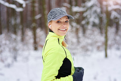 Portrait of smiling woman running in winter time