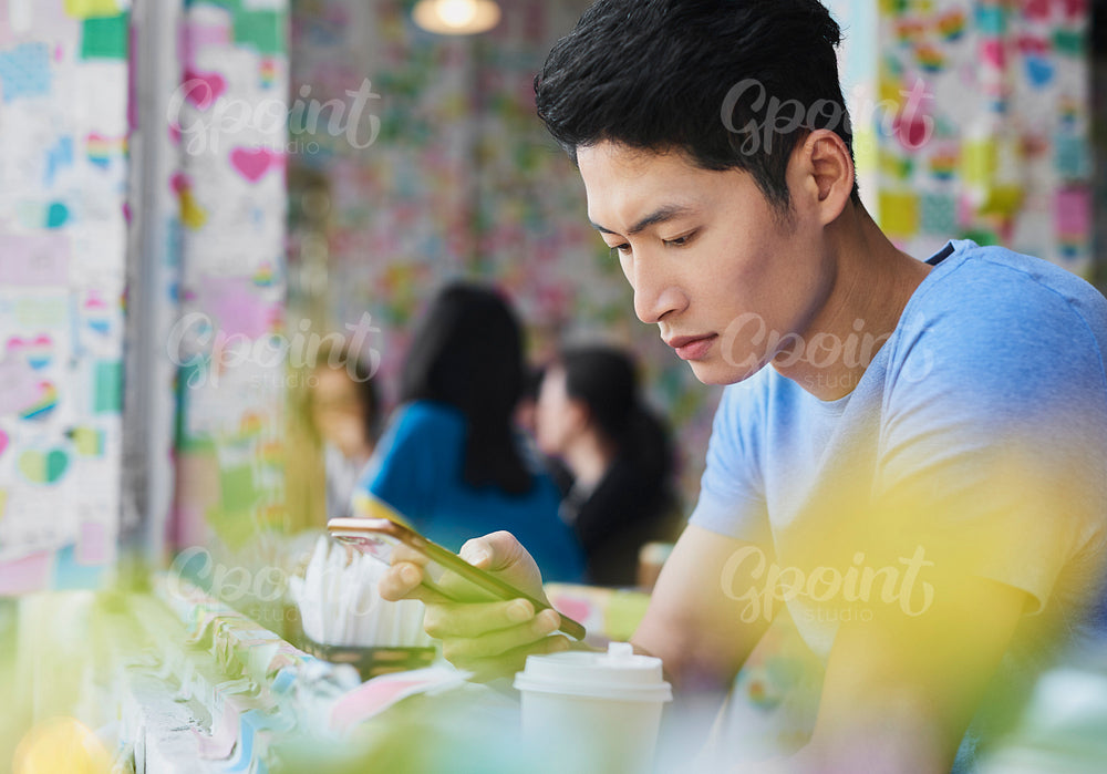 Close up of Vietnamese man with mobile phone at cafe