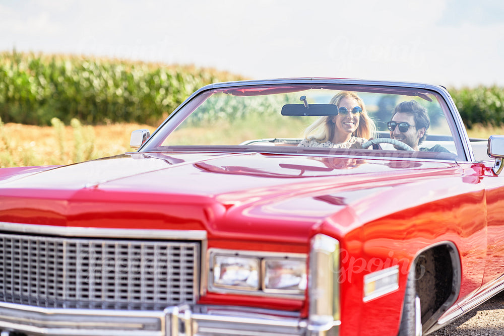 Smiling couple in a red old car