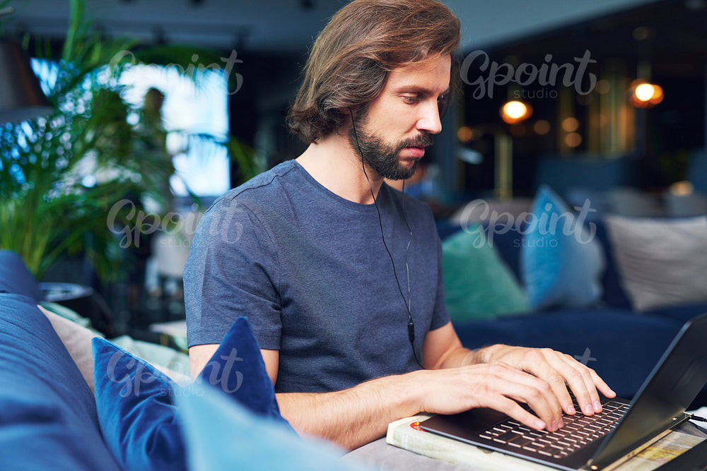 Focused man with headphones using a laptop